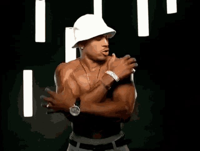a shirtless man is wearing a white hat and a cross necklace