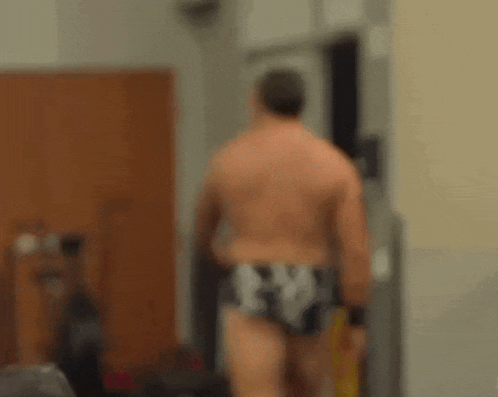 a wrestler in a gym with a caution sign on the floor