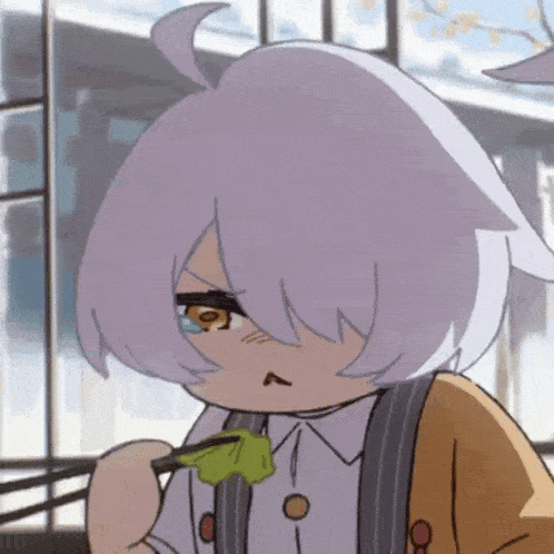 a close up of a cartoon character eating a green leaf with chopsticks .
