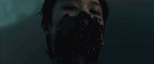 a close up of a person 's face with black liquid coming out of it