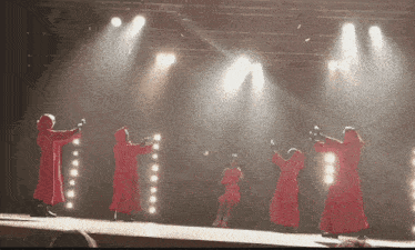 a group of people standing on a stage holding microphones