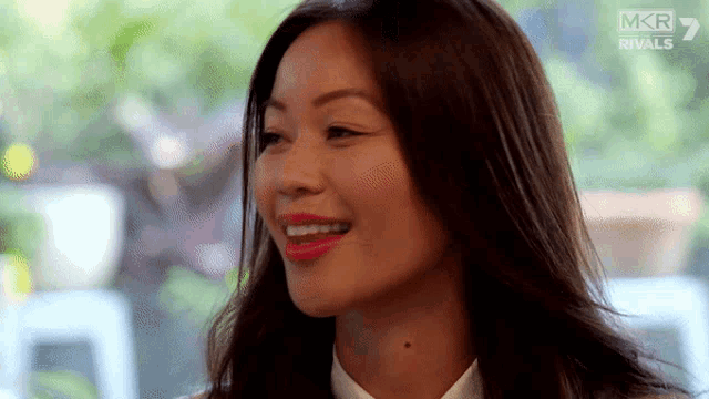 a close up of a woman 's face with a mkr rivals logo in the corner