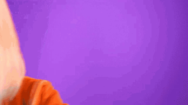 a close up of a woman 's face against a purple background .