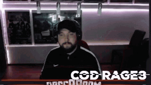 a man with a beard is wearing headphones in front of a screen that says cod rage 3