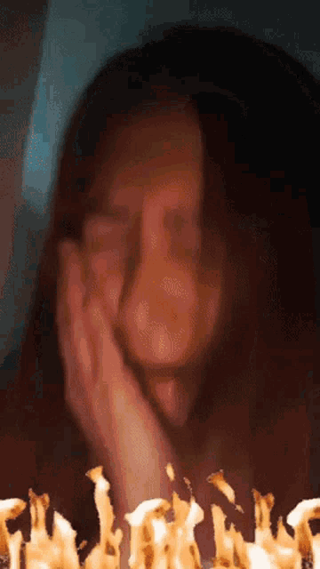 a blurred image of a woman with her hand on her face