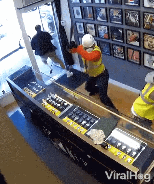 a man in a hard hat stands in front of a counter with watches on it and the words viralhog on the bottom