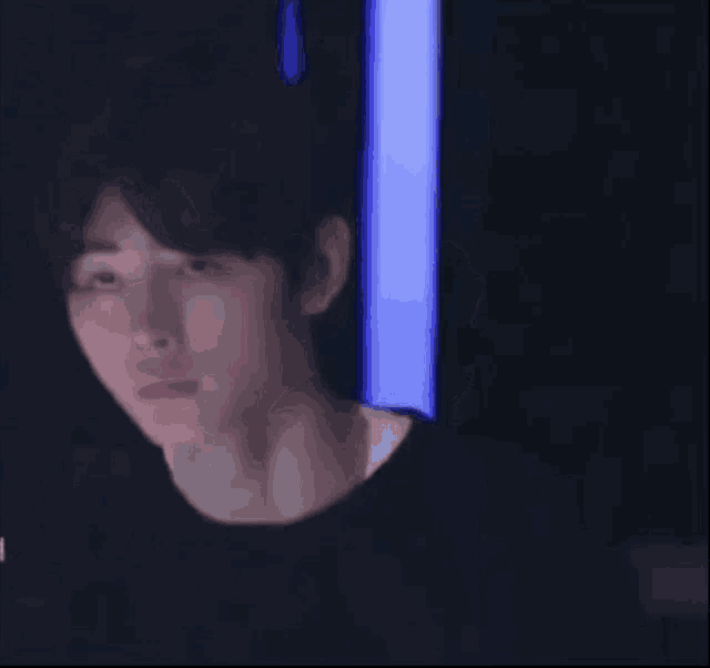 a close up of a person 's face with a blue light behind them .