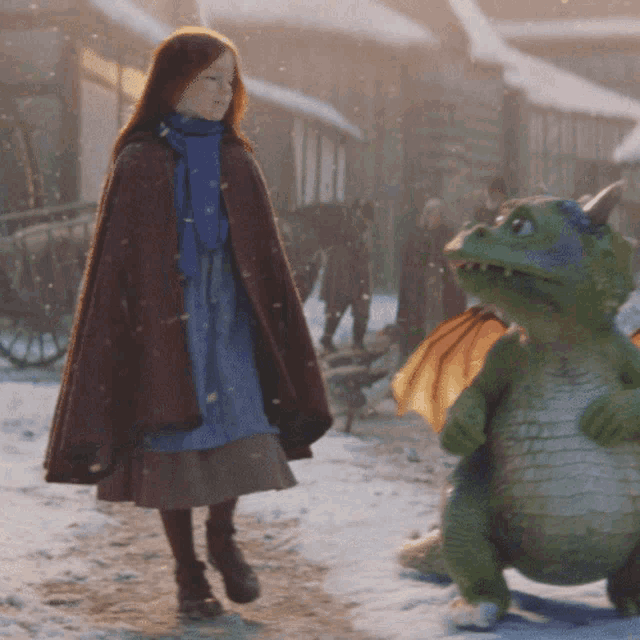 a girl in a cape stands next to a dragon in the snow