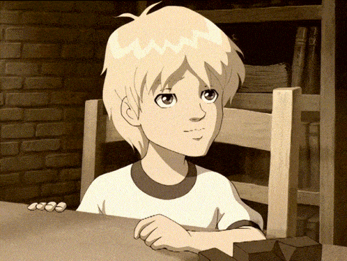 a boy with blonde hair is sitting at a table in front of a brick wall