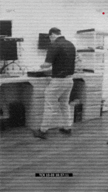 a black and white photo of a man standing in front of a desk that says tcr 10-09 18 37 11 on it