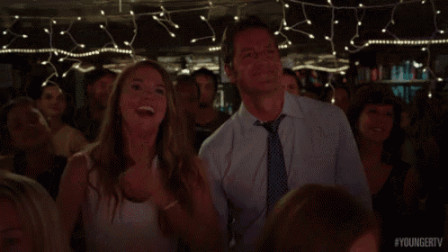 a man and a woman are dancing in a crowd at a party
