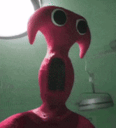 a close up of a red stuffed animal with a big mouth