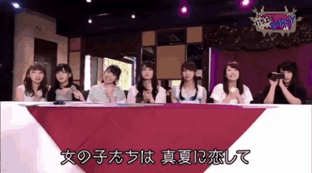 a group of women sitting at a table with chinese writing