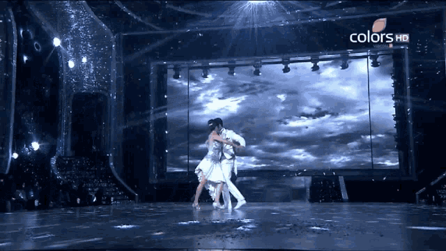 a couple dancing on a stage with the words colors hd on the bottom left