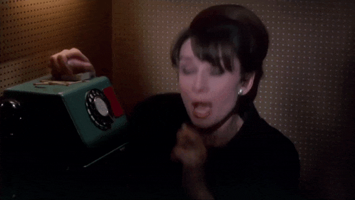 a woman is screaming while talking on a green phone