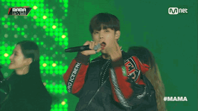 a man singing into a microphone with the word mama on the screen