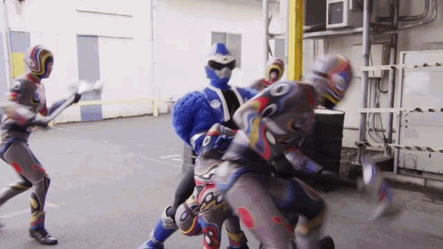 a group of superheros are fighting in a parking lot and one of them has the number 8 on his pants