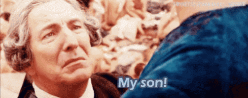 a man in a wig is talking to a woman in a blue dress and says my son