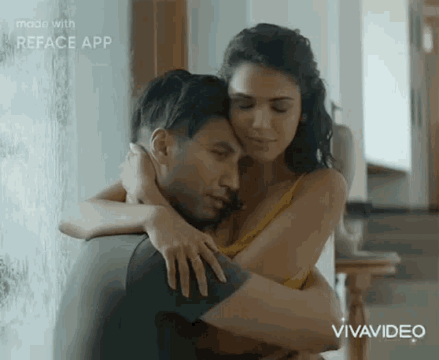 a man and a woman are hugging each other while sitting in front of a window .
