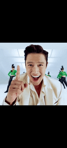 a man in a white suit is making a funny face and pointing up