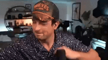a man wearing a hat is sitting in a chair in a living room .