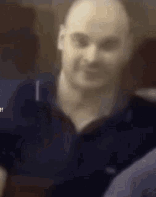 a close up of a bald man 's face in a blurry photo