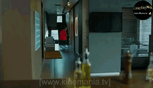 a woman in a red jacket is carrying another woman on her shoulders in a kitchen ..