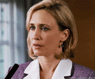 a close up of a woman wearing a purple suit