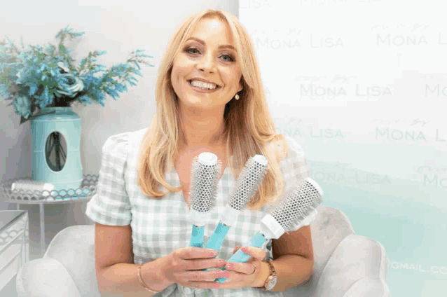 a woman in a plaid shirt is holding three brushes in front of a wall that says mona lisa