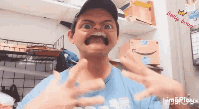 a man making a funny face with betty boop written on the wall
