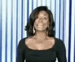 a woman in a black dress is standing in front of a blue and white striped curtain .