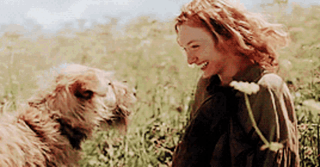 a woman is smiling while standing next to a dog