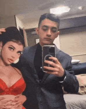 a man in a suit is taking a selfie with his phone