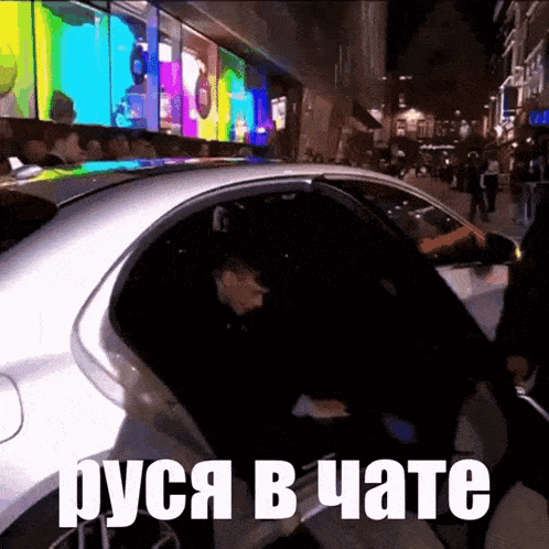 a man is getting out of a car with the words " руся в чате " above him