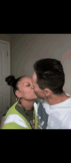 a man and a woman are kissing in a room