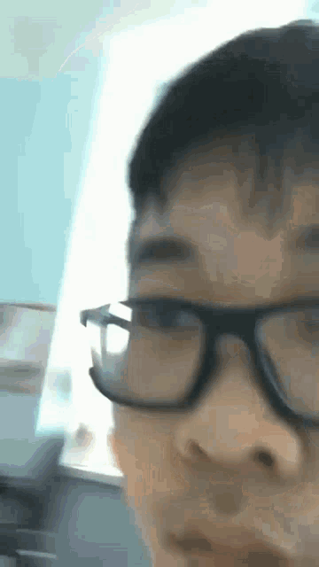 a close up of a person wearing glasses with a blurry background