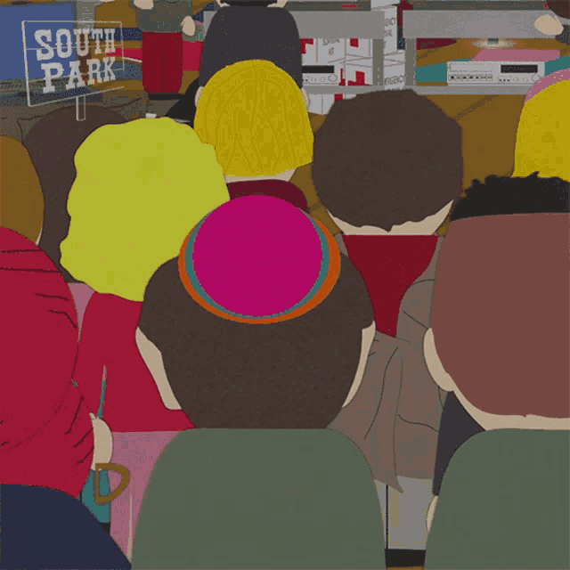 a crowd of people sitting in front of a south park sign