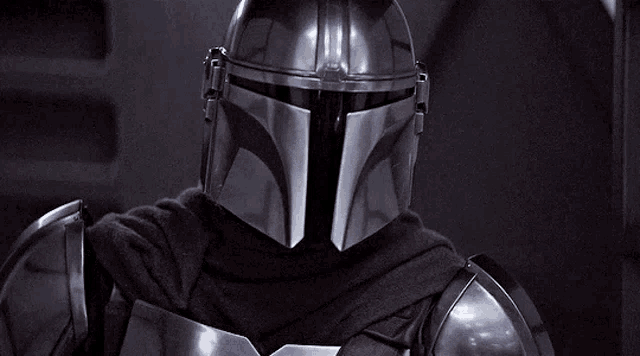 a close up of a person wearing a helmet and armor in a dark room .