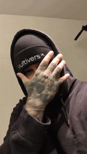 a man wearing a beanie that says " multivers " on it