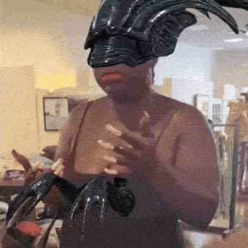 a woman wearing a black helmet with horns is holding a claw