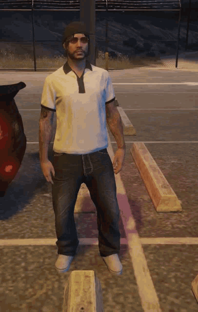 a man standing in a parking lot wearing a white shirt and black jeans