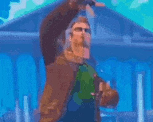 a cartoon man with a mustache and glasses is standing in front of a brick wall .