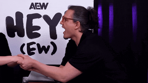 a man shaking hands in front of a sign that says hey ew