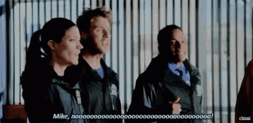 a group of people are standing in front of a fence and one of them is saying " mike "