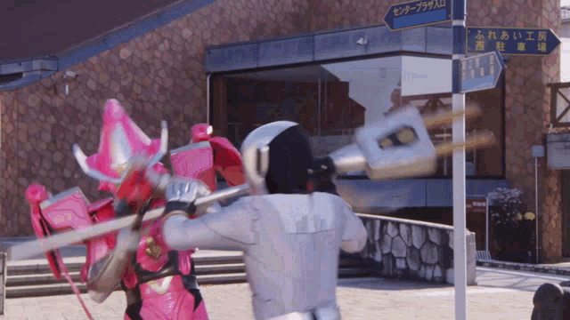 a man in a white suit is holding a sword in front of a building with chinese writing on it
