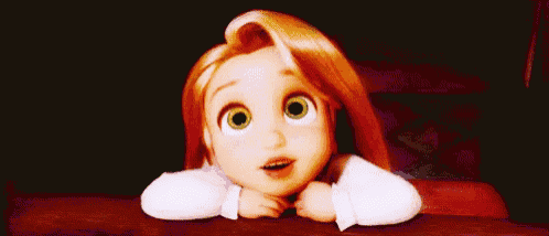 a little girl with long hair and green eyes is sitting at a table with her head on her hands .