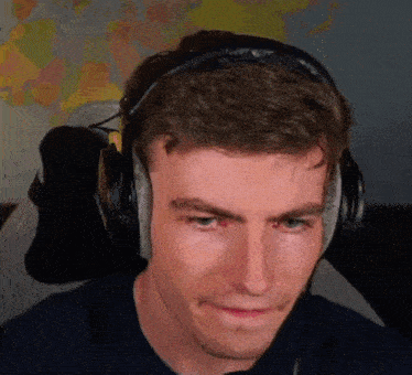 a man wearing headphones is sitting in a chair and making a face .