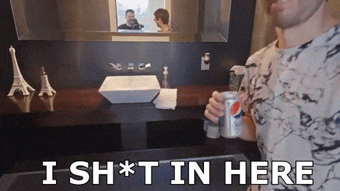 a man holding a can of pepsi in front of a bathroom sink with the words i sh * t in here