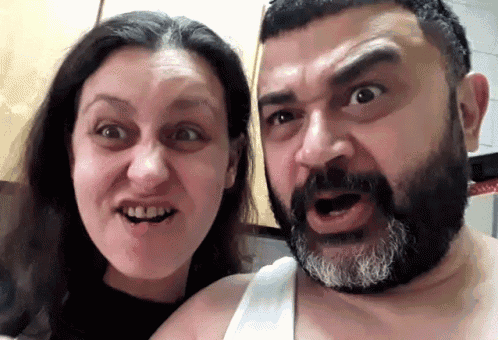a man with a beard is making a funny face with a woman