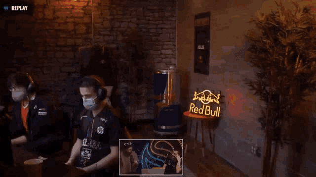 a man wearing a mask is dancing in front of a sign that says red bull